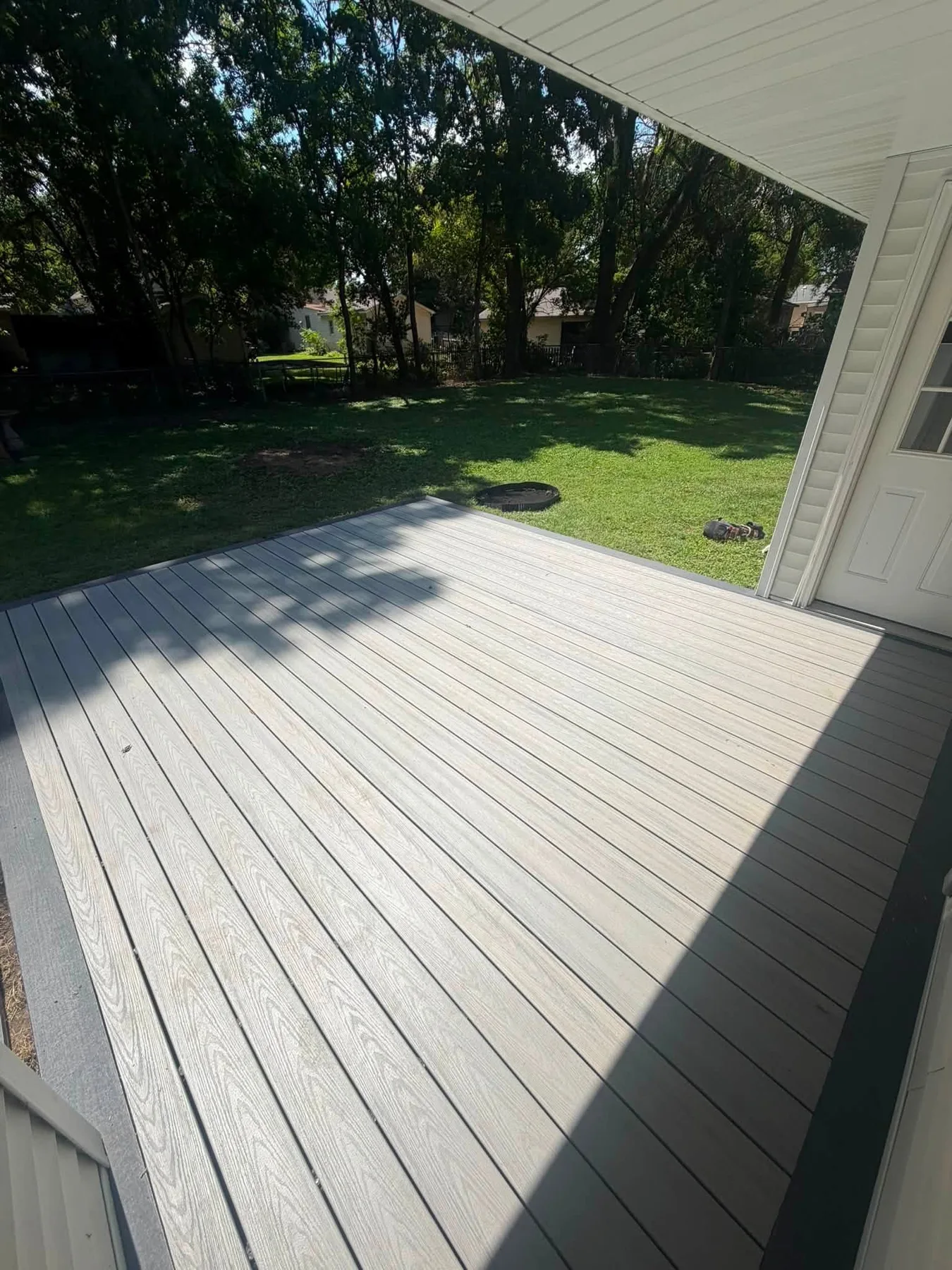 Completed low-profile gray deck under a covered area