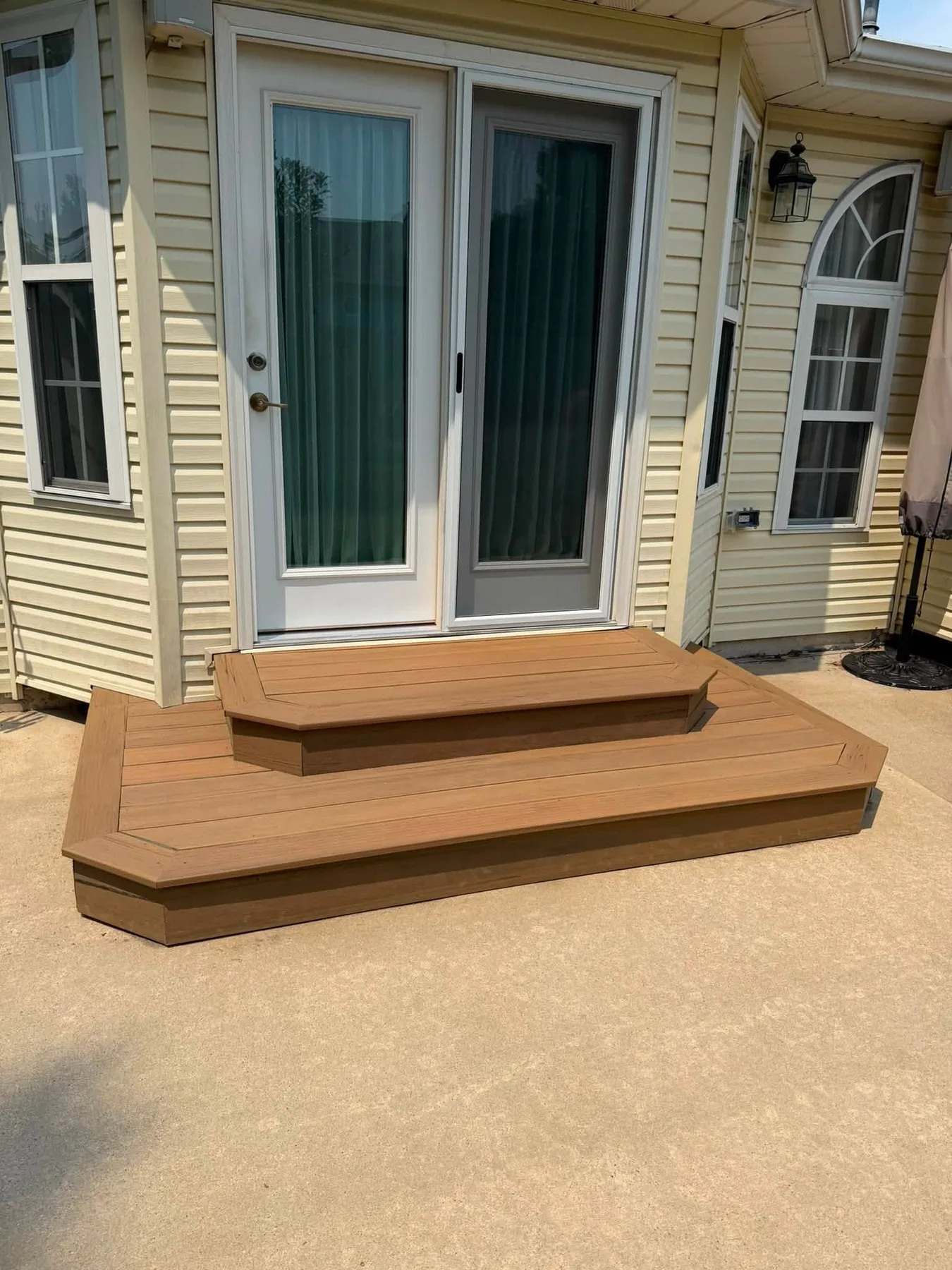 Finished brown entry steps beneath a sliding patio door