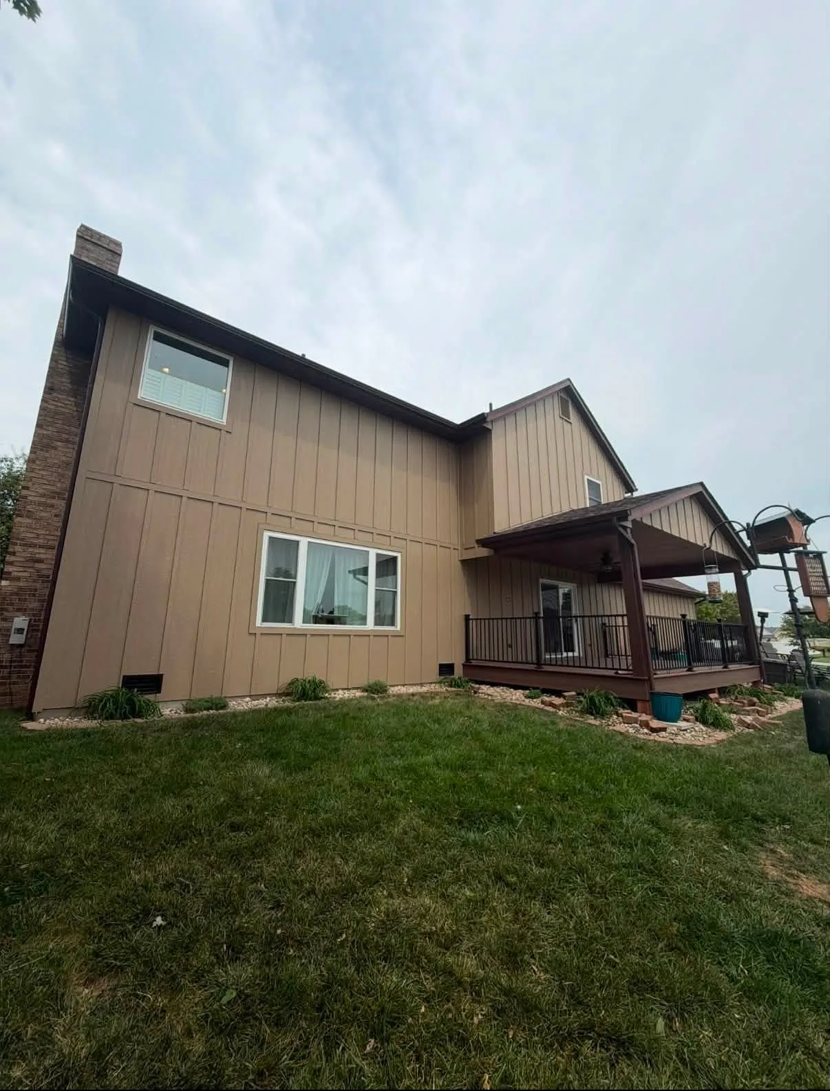 Completed side and rear exterior with brown siding and white trim
